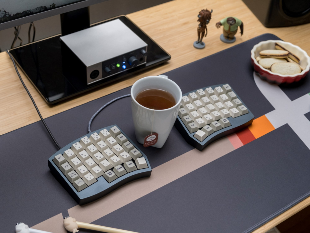 Image of Altair on deskmat with coffee cup in between both halves