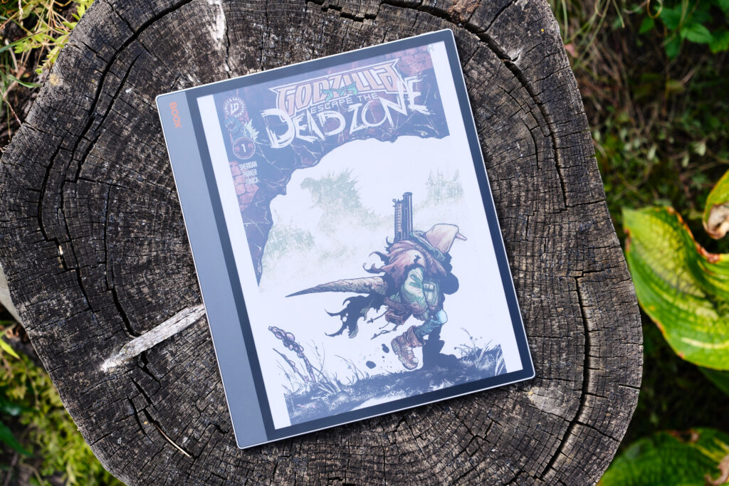 Boox Tab X C with Godzilla comic on screen while device lays on tree stump
