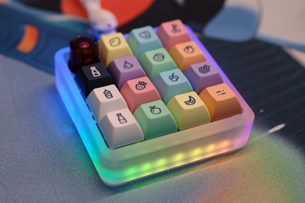 Vault 16 macropad laying on deskmat with LEDs on, shot at an angle