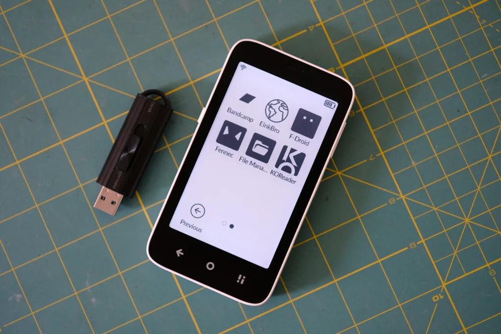 Mudita Kompakt next to usb stick to show size