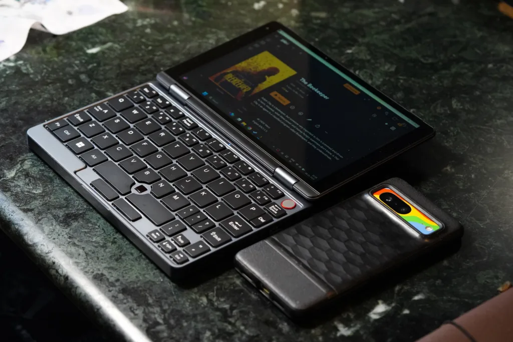 X-Plus Piccolo Netbook next to phone to show size