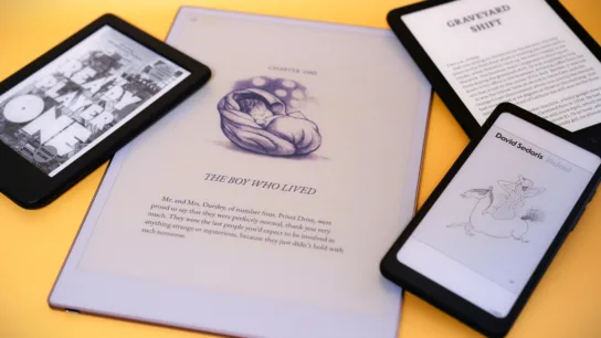 Small pile of e-readers from different brands on yellow backgroun