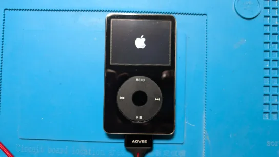 iPod on blue soldering mat with Apple icon on screen